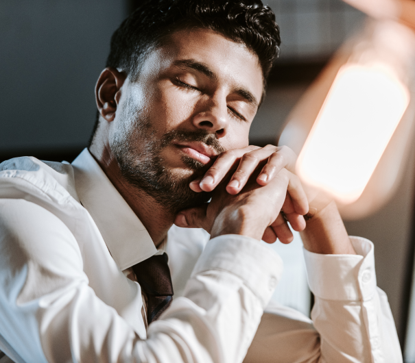 Young businessman falling asleep at his desk
